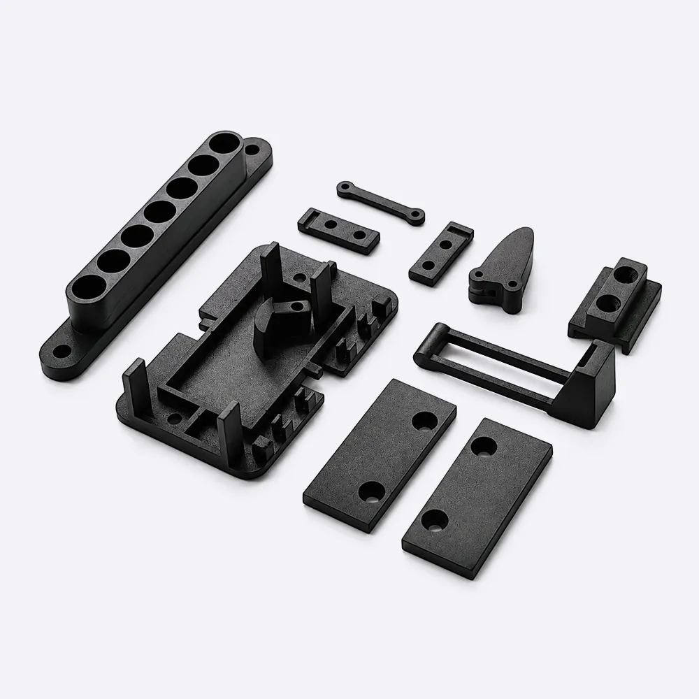 Black spray-painted SLA resin parts arranged on a neutral production surface.