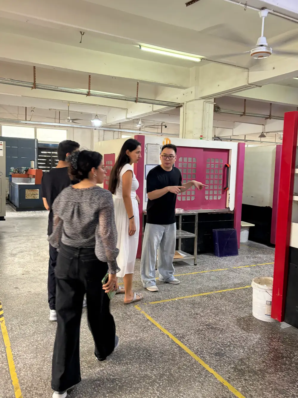 HERUIYUN engineer guiding visiting customers through the machining area