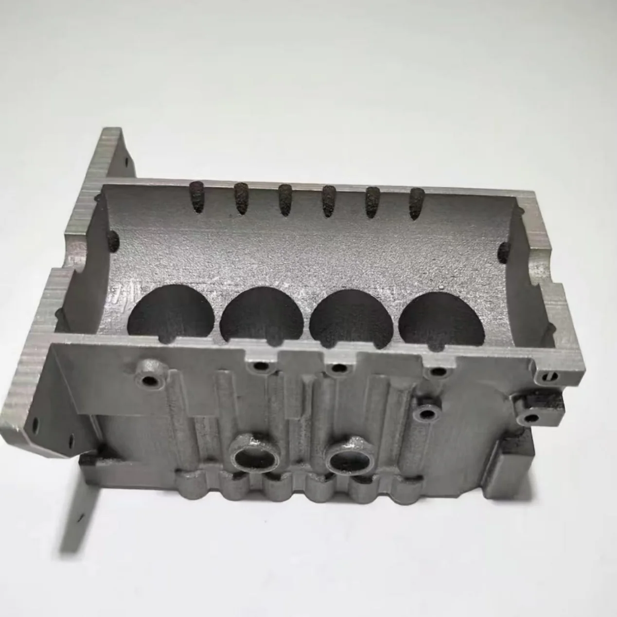 Metal housing sample with open cavities, circular openings and mounting features